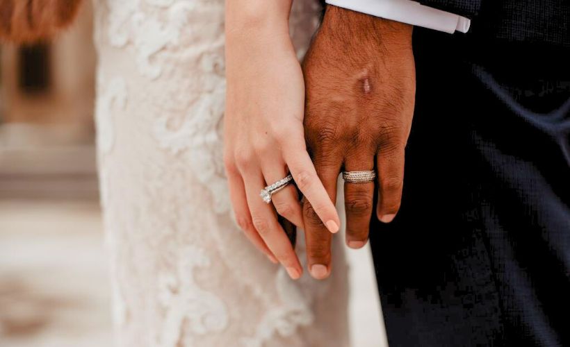 a closeup shot of bride and groom's hand, showcasing their wedding rings